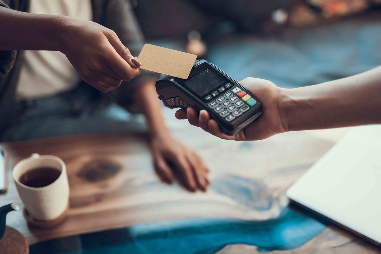 Customer making a contactless credit card payment at checkout